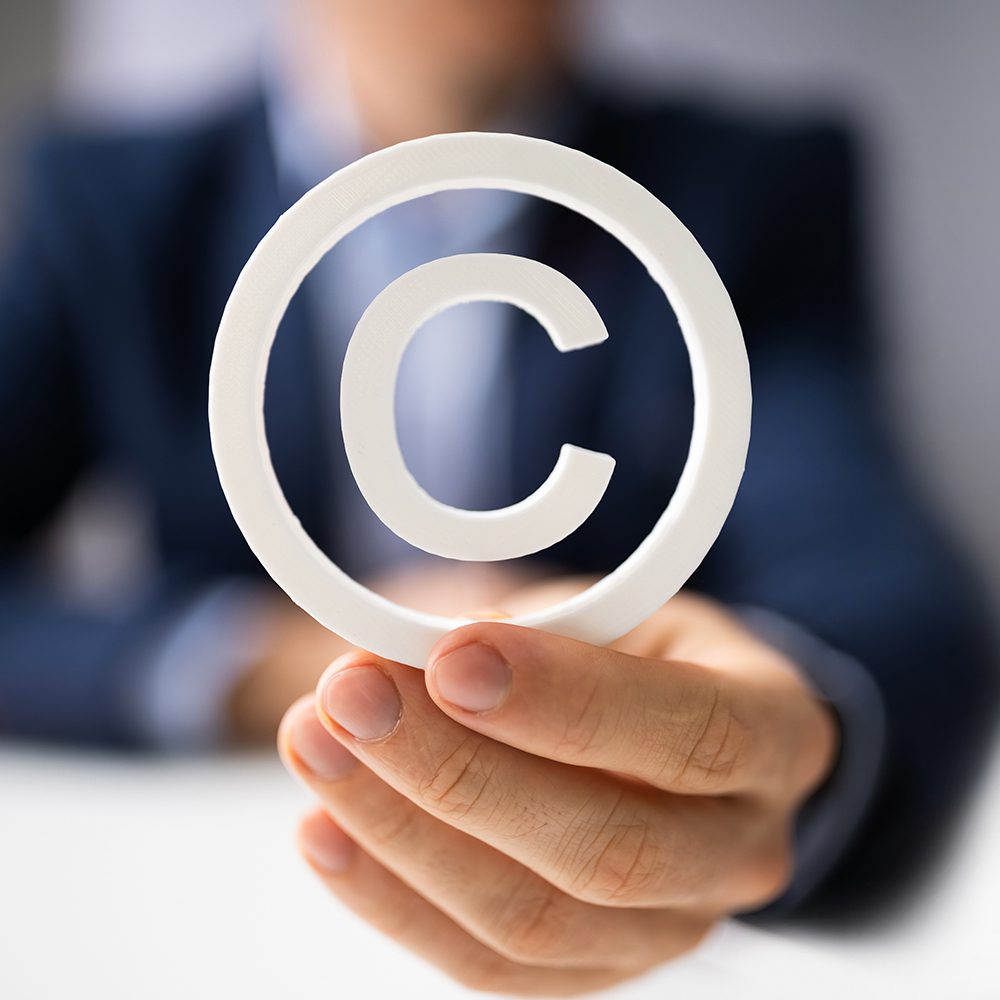 Person holding a copyright symbol, symbolizing the transfer of copyright.